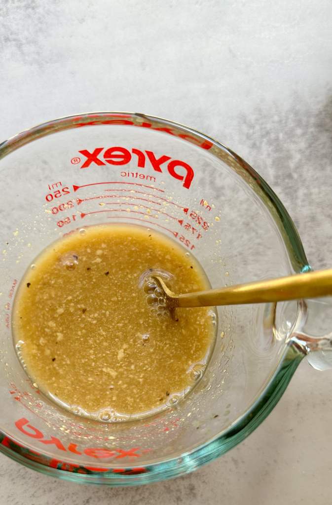 oil-free apple cider vinaigrette in a glass measuring cup