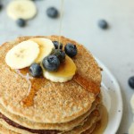 banana oat pancakes with syrup being poured on top