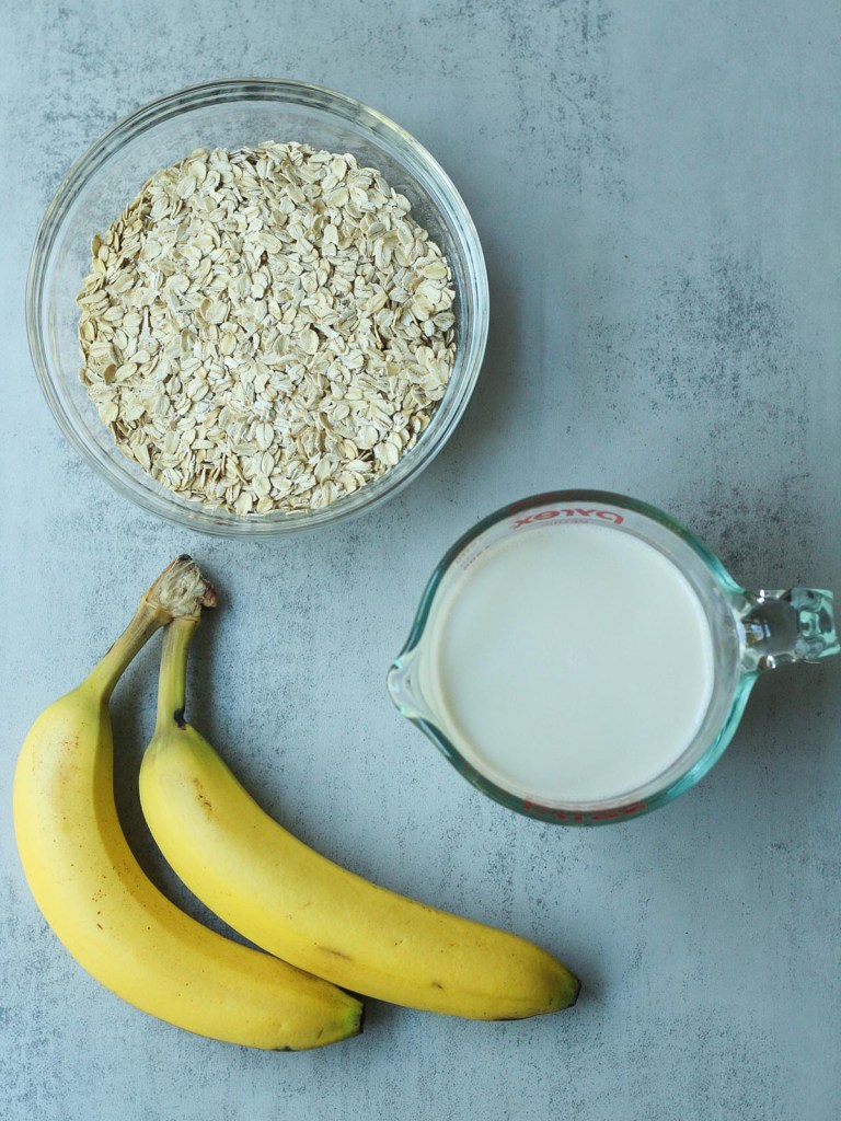 ingredients for banana oat pancakes on grey background