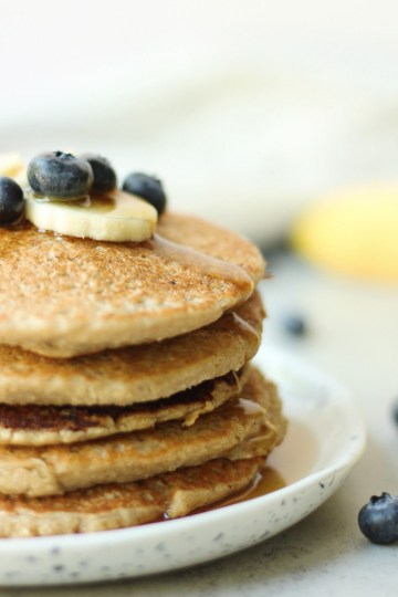 stack of banana oat pancakes with syrup running down