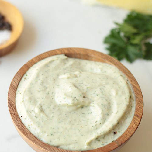 vegan garlic tahini dipping sauce in a wooden bowl