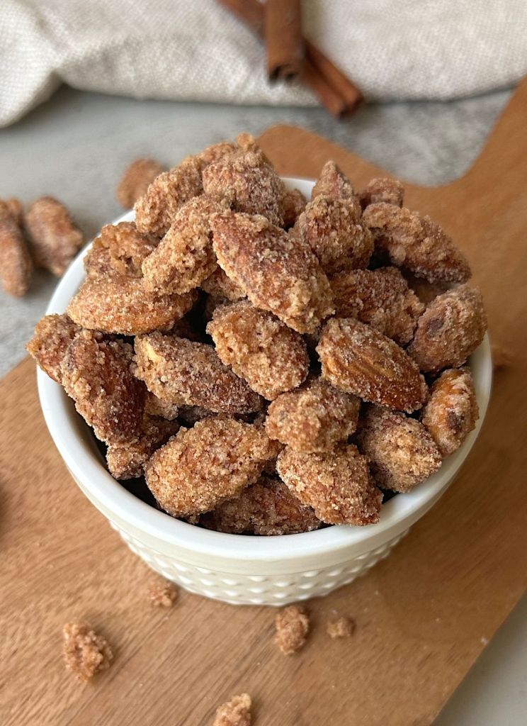 finished vegan cinnamon sugar candied almonds in a white bowl
