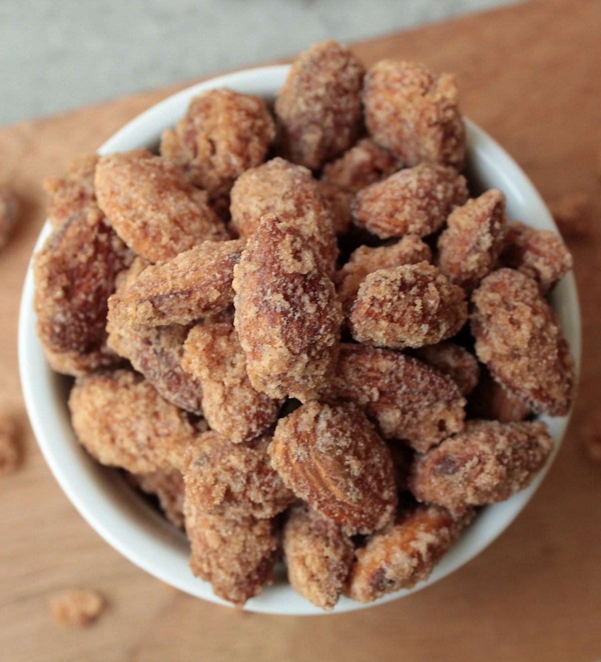 Top view vegan cinnamon sugar candied almonds in a white bowl