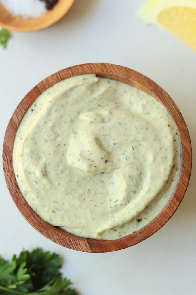 vegan garlic tahini dipping sauce in a wood bowl
