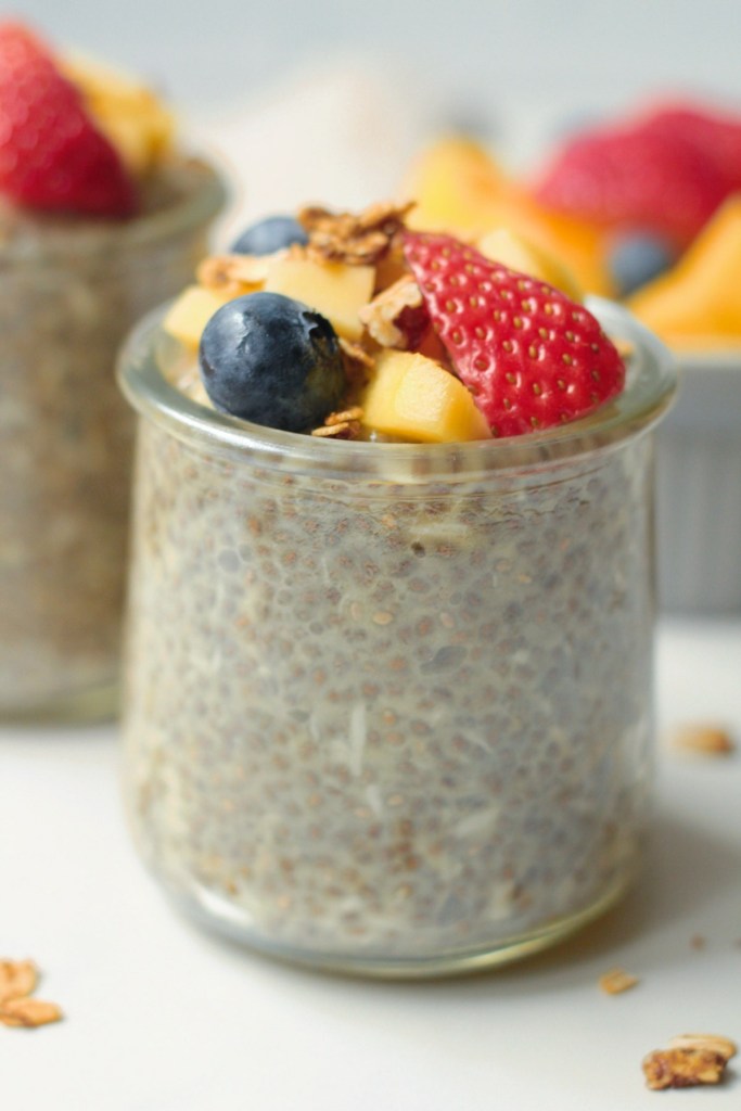 vegan coconut mango chia pudding topped with fruit and granola
