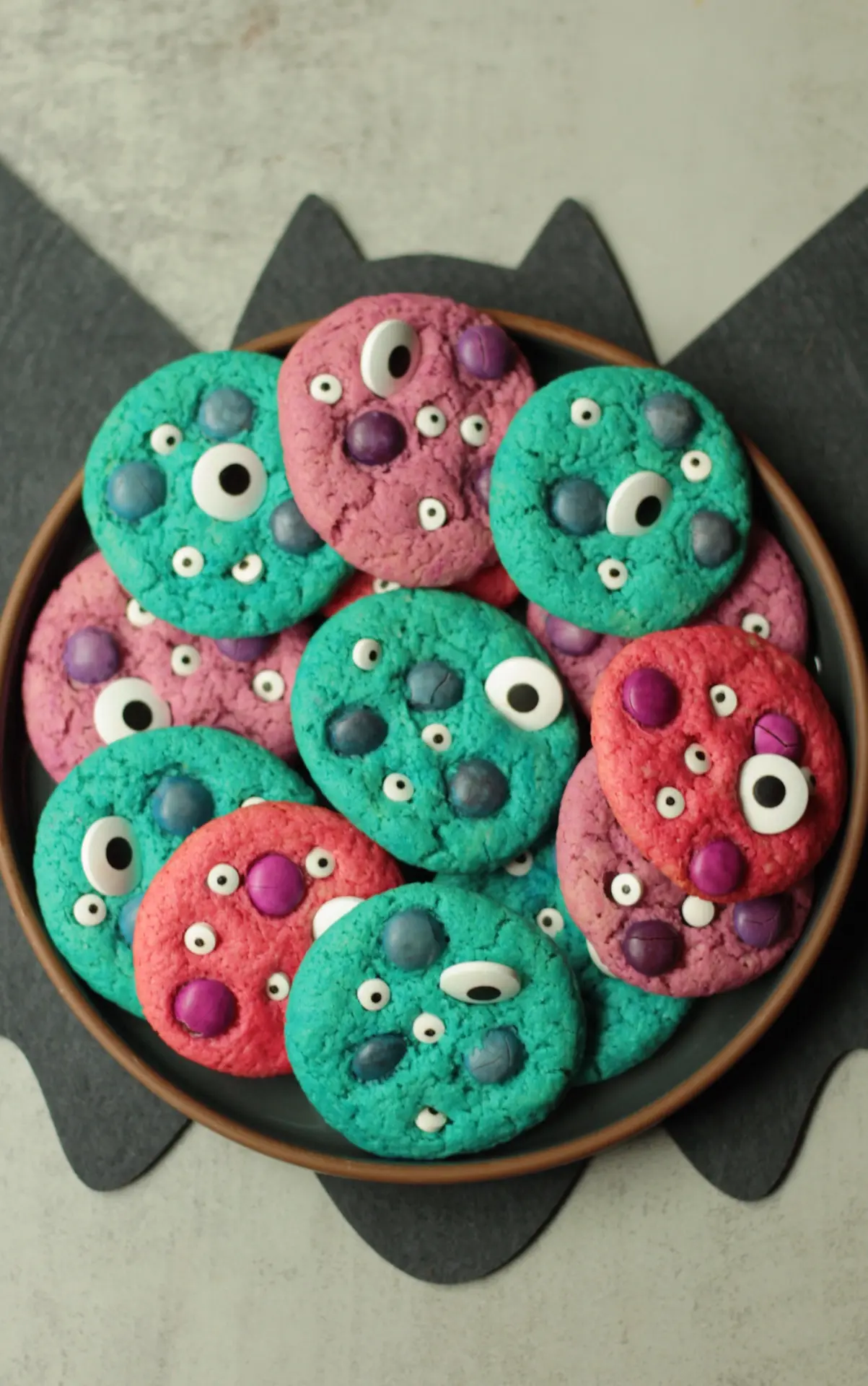 Allergy-friendly Halloween Monster Cookies on a plate with a bat cut out behind it