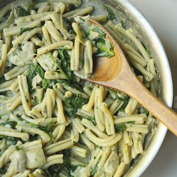 creamy vegan spinach artichoke pasta in pan