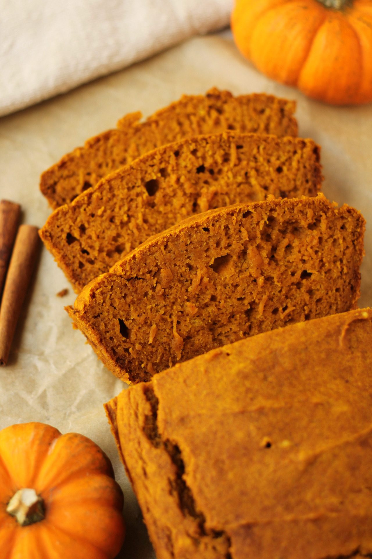 finished loaf of vegan pumpkin bread with three slices cut