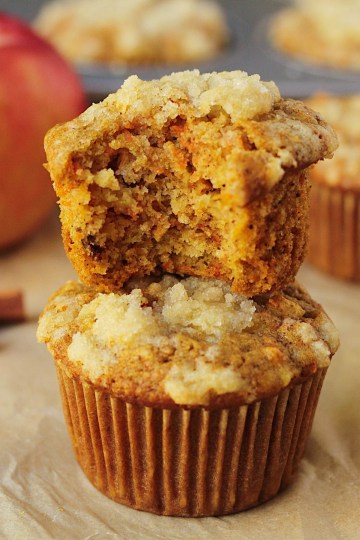 vegan carrot apple muffins stacked with a bite taken out of the top one