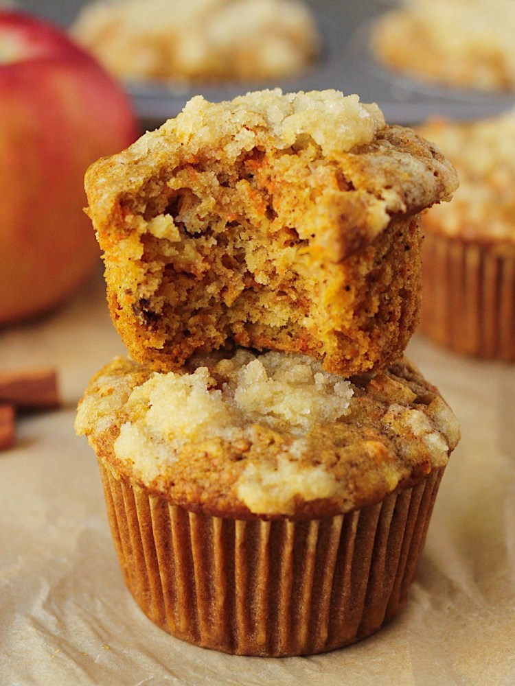 vegan carrot apple muffins stacked with a bite taken out of the top one