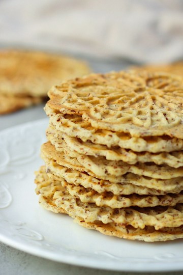 vegan lemon pizzelle stacked on a white plate