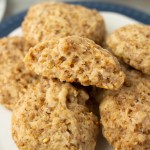 steel cut oatmeal cookies on a plate with one cookie broken open to show texture