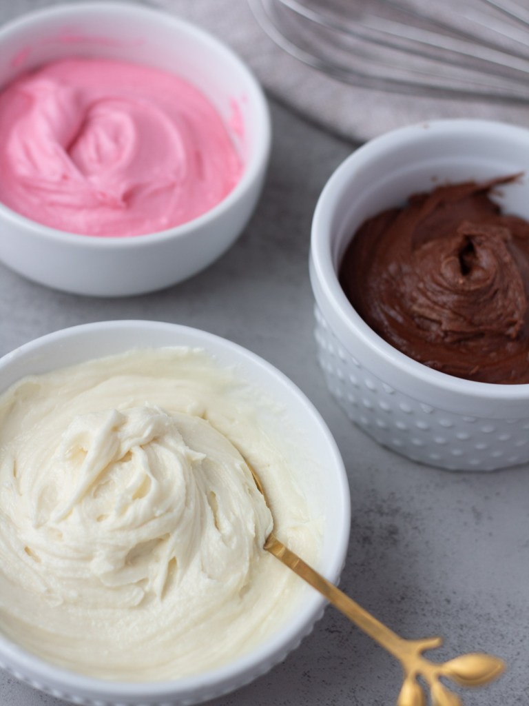3 flavors of vegan cake frosting in separate bowls
