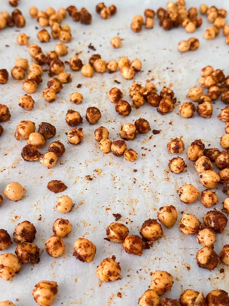 uncooked chickpeas on a parchment-lined baking sheet