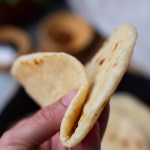 tortilla being folded by a hand to show softness