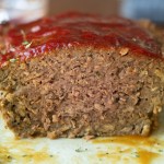 Close up view of meatloaf with slice cut off.
