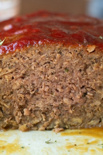 Close up view of meatloaf with slice cut off.